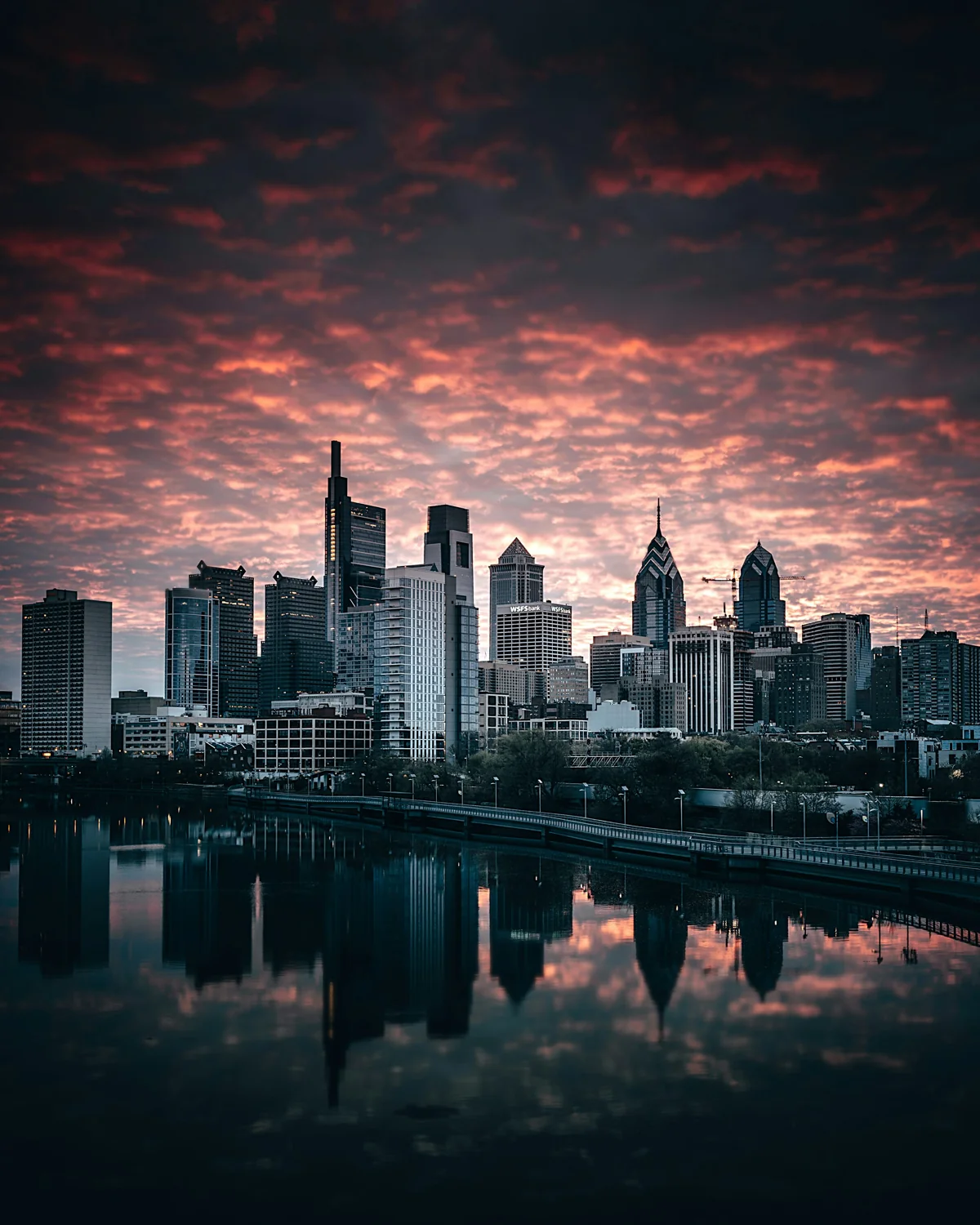 Cleveland's skyline reflected in the Cuyahoga River under a sunset sky